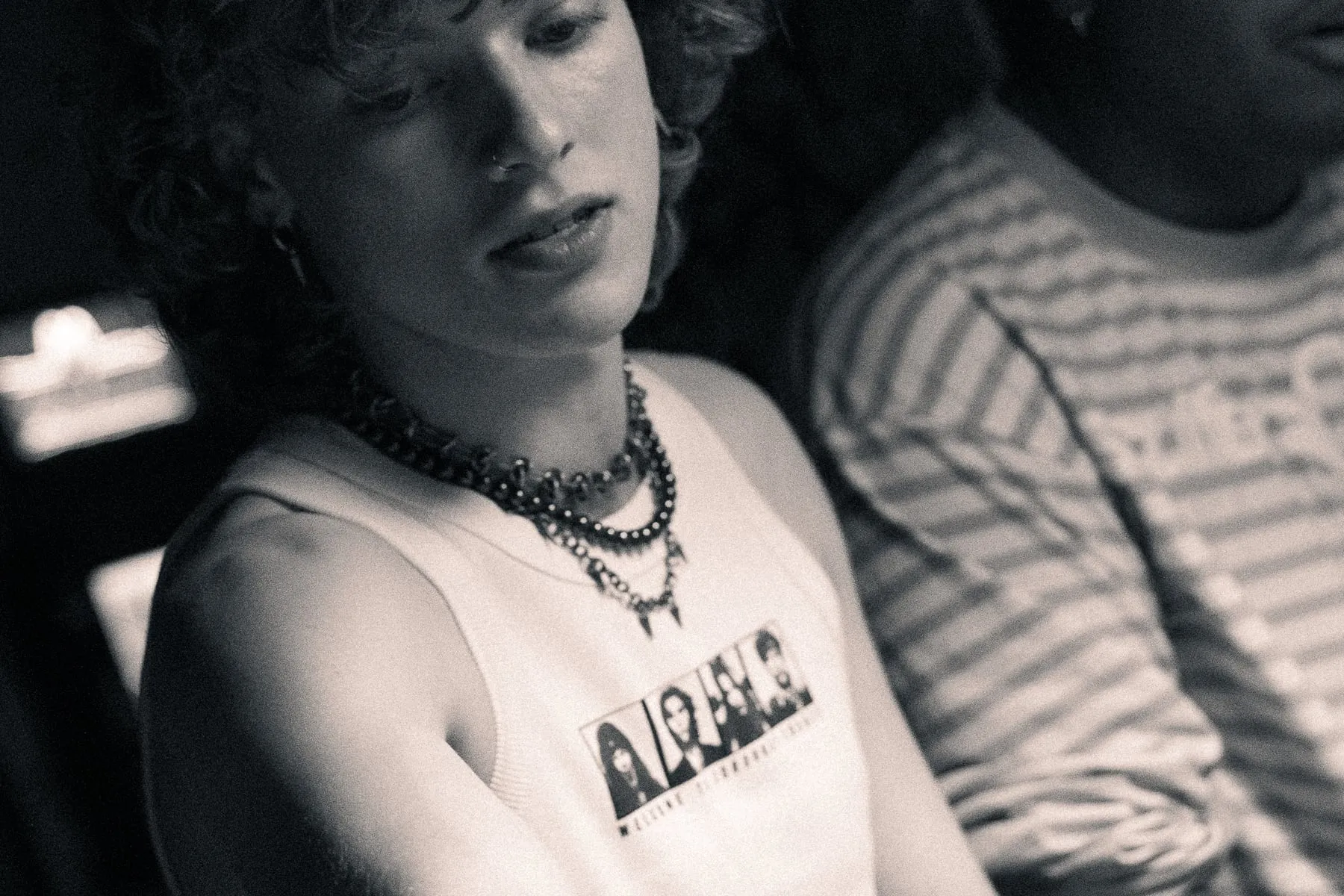 The crop tank worn at a venue, the four-portrait print visible across the chest.
